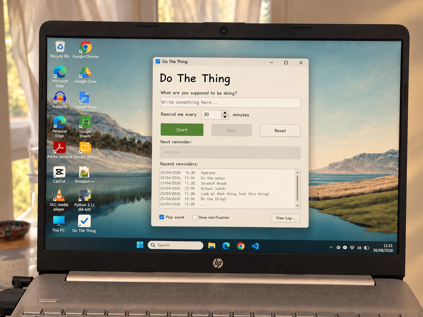A softly muted photograph of a laptop displaying the Do The Thing reminder app.